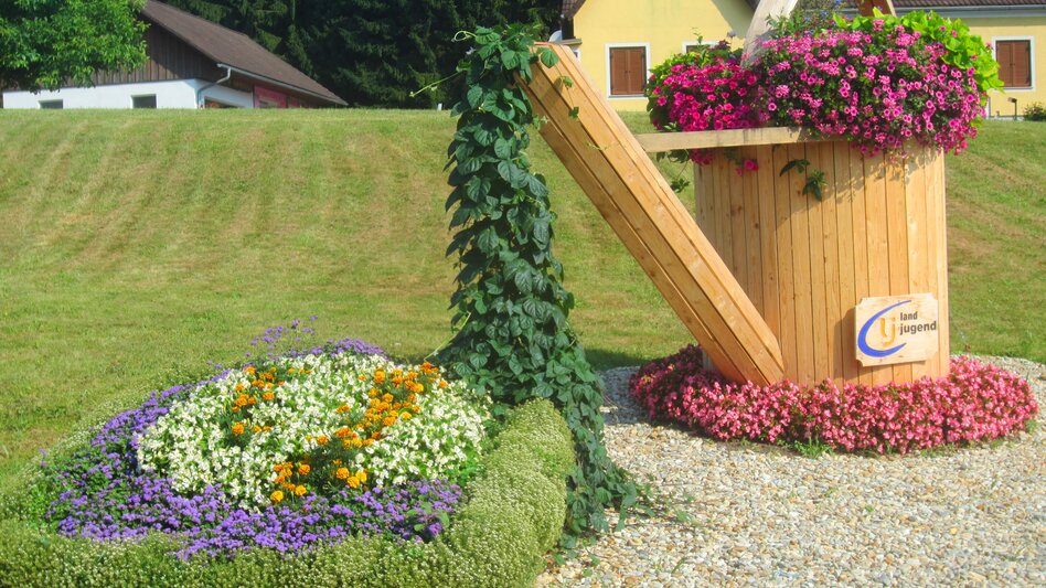 Holzgießkanne mit Blumenbeet in Großwilfersdorf | © Gemeinde Großwilfersdorf
