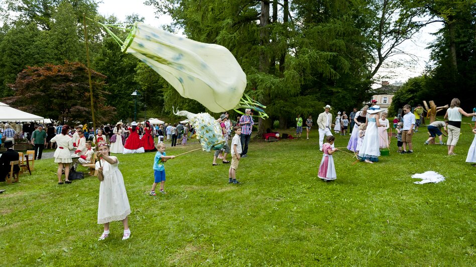 Kinder spielen mit Windspielen am Biedermeierfest in Bad Gleichenberg