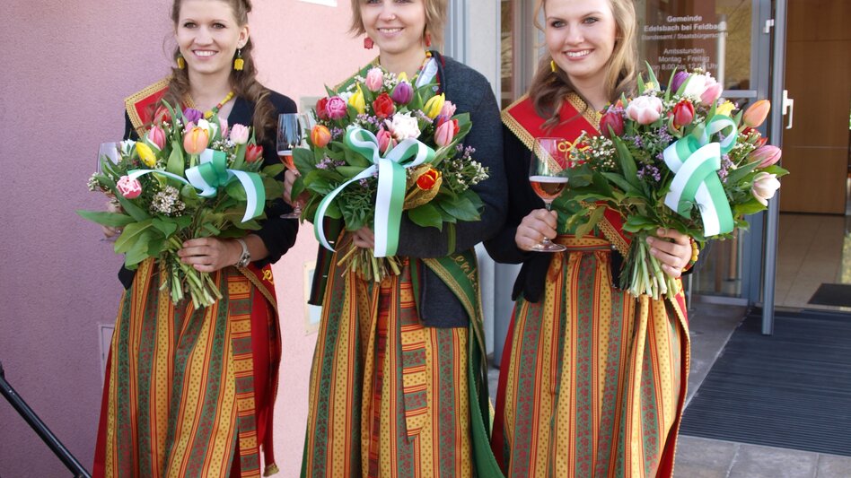Drei Frauen im Dirndl mit bunten Tulpensträußen | © Gemeinde Edelsbach