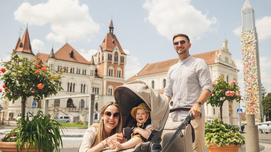 Pärchen mit Kinderwagen vor dem Rathaus in Feldbach