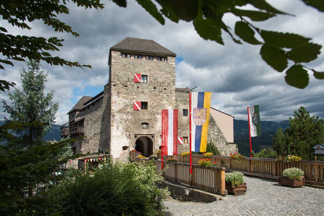 Eine Burg mit Zugbrücke, Blumen und Fahnen