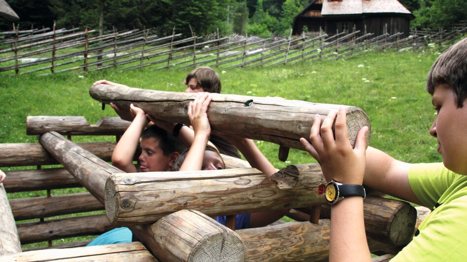 Kinder bauen im Rahmen eines Schulprogrammes ein Blockhaus