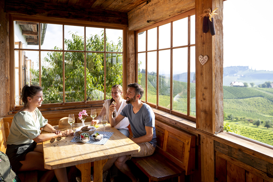 Wanderpause beim Buschenschank mit Blick auf die südsteirischen Weinberge | © STG | Tom Lamm
