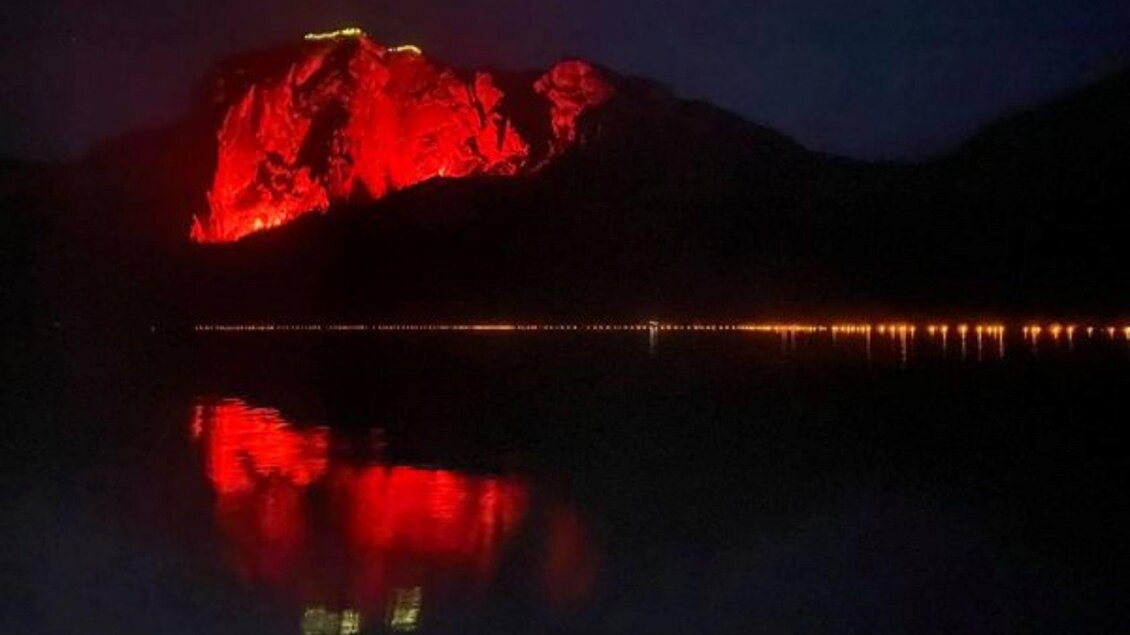 Die imposante Trisselwand am Ufer des Altausseer Sees wird bei Berge in Flammen nachts von dem rotem Licht der bengalischen Feuer beleuchtet | © Fremdenverkehrsverein Altaussee