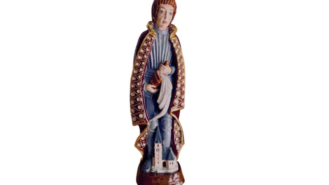Die bemalte keramische Figur wird in der Ausstellung KeraMik im Kammerhofmuseum ausgestellt, und zeigt eine stehenden Person in historischer Kleidung. Zu ihren Füßen befindet sich ein kleines Kirchenmodell. | © Kammerhofmuseum Bad Aussee, kammerhofmuseum.at
