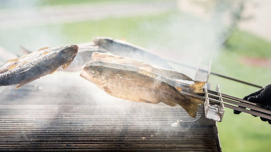 Frischer Fisch wird auf einem Grill zubereitet. Dampf steigt auf, während die Fische gleichmäßig gegart werden. | © Tauroa