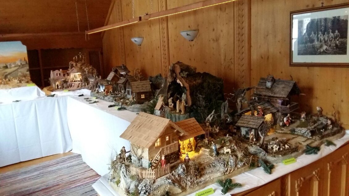 Eine liebevoll gestaltete Krippe mit vielen kleinen Häusern und Figuren. Der Raum hat eine rustikale Holzverkleidung und ist festlich dekoriert. | © Petra Kirchschlager