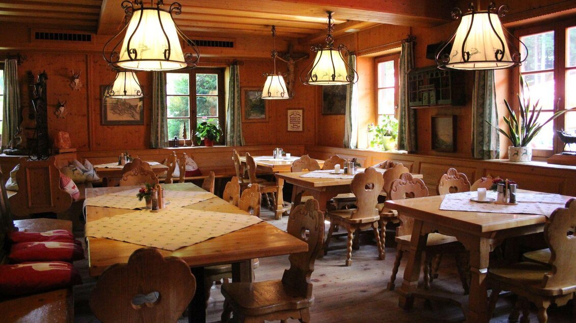<p>Die gemütliche Gaststube vom Wirtshaus auf der Blaa Alm ist mit viel Holz verkleidet. Die Tische sind festlich gedeckt und einladend.</p> | © Viola Lechner