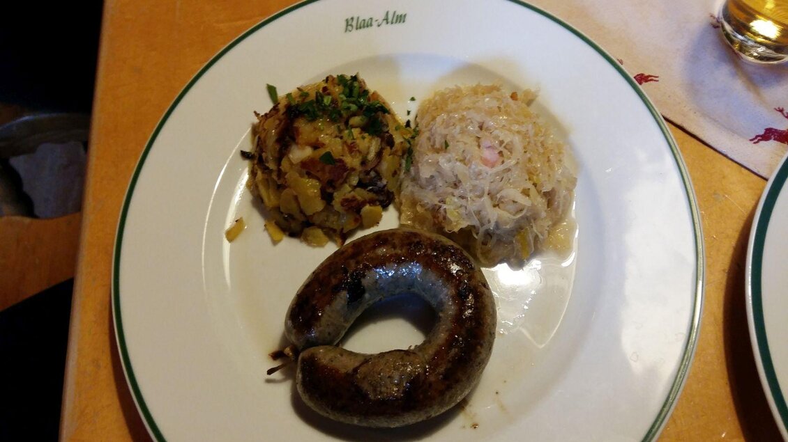 Ein Teller mit einer Leberwurst, welche beim Wurstschmaus auf der Blaa Alm serviert wird. Sauerkraut und Kartoffeln dürfen dabei nicht fehlen.  | © Petra Kirchschlager