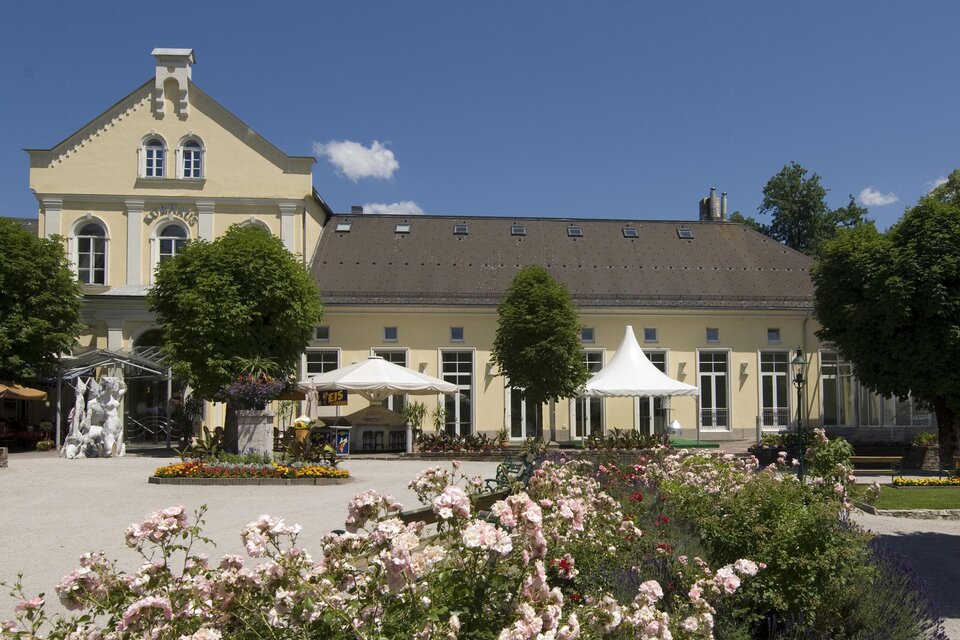 <p>Das gelbe Kur- und Congresshaus in Bad Aussee ist jährlich Zentrum von zahlreichen Veranstaltungen. Bunte Blumen und Bäume umgeben die Terrasse mit Sonnenschirmen.</p> | © TVB Ausseerland - Salzkammergut_Rastl