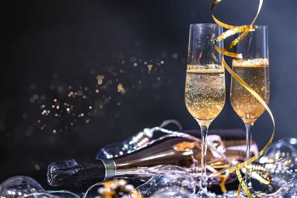 Zwei Gläser mit Sekt stehen auf einem Tisch, umgeben von Glitzer und Dekoration. Es strahlt eine festliche Stimmung aus. | © Pixabay