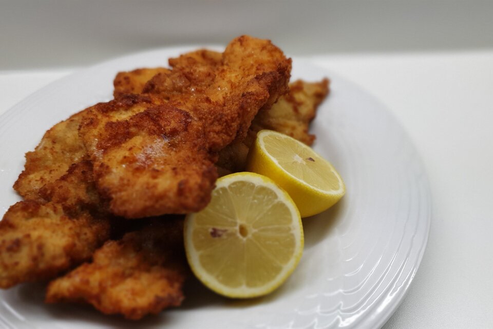Frittierte Fischfilets auf einem Teller mit frischen Zitronenscheiben. Die goldbraune Panade macht das Gericht appetitlich. | © Pixabay
