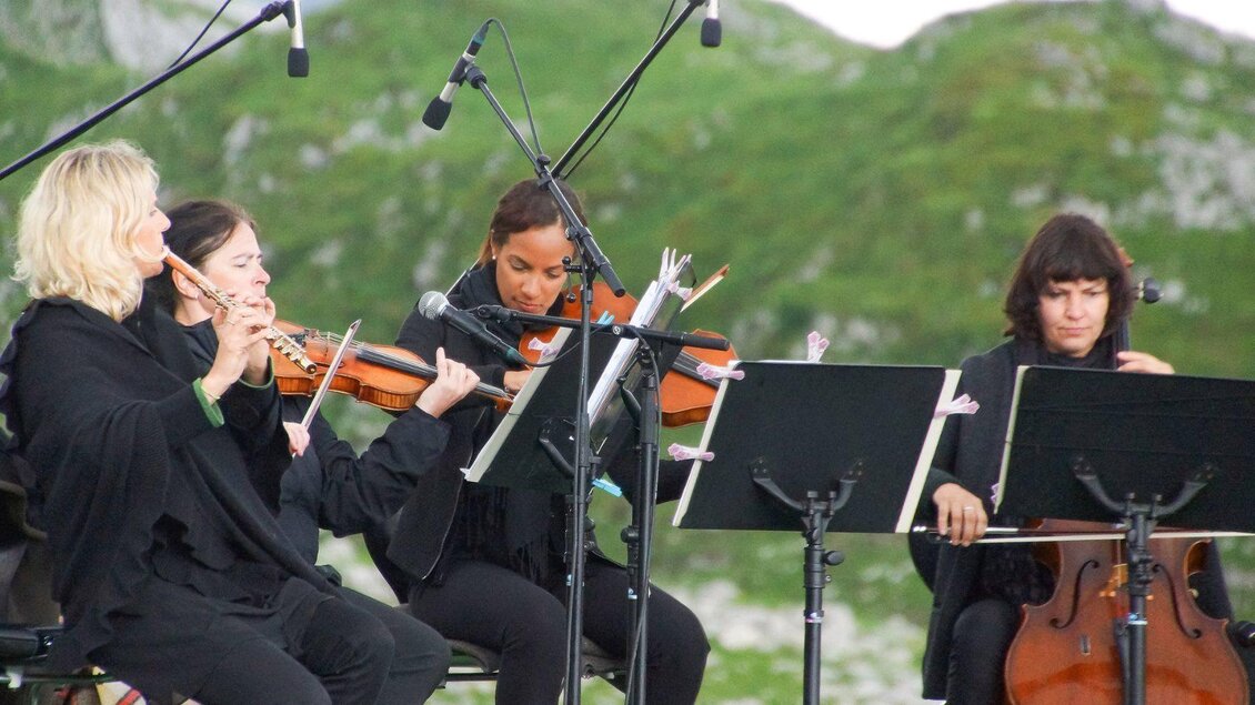 Eine Gruppe von vier Musikerinnen spielt Instrumente im Freien. Im Hintergrund sind grüne Hügel zu sehen. | © ARF_Hilbrand