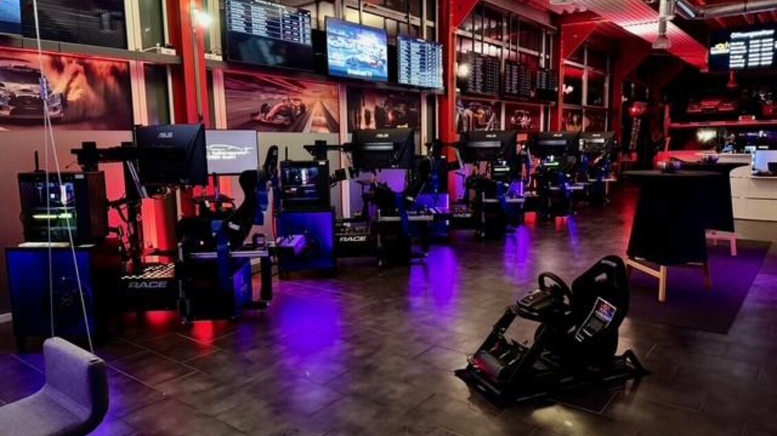 Ein moderner E-Sport-Bereich mit mehreren Rennsimulatoren und Bildschirmen. Die Atmosphäre wird durch bunte Lichter und eine stilvolle Einrichtung betont. | © Thomas Zach