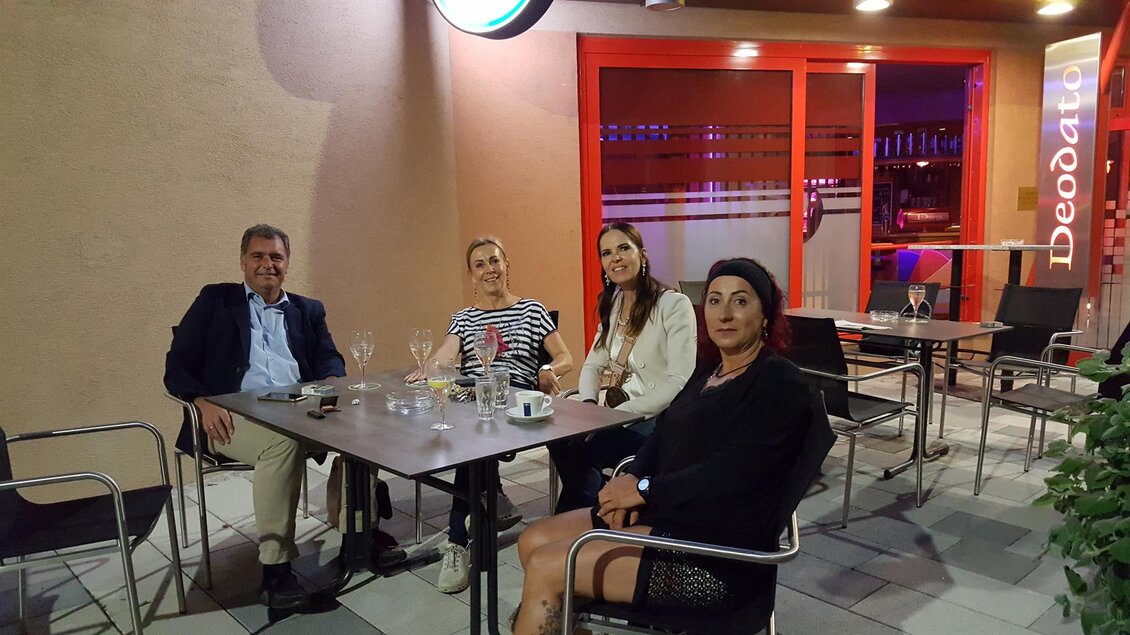 Eine Gruppe von vier Personen sitzt an einem Tisch in einem Restaurant. Die Atmosphäre ist entspannt und die Beleuchtung ist abends. | © Susanne Seidl