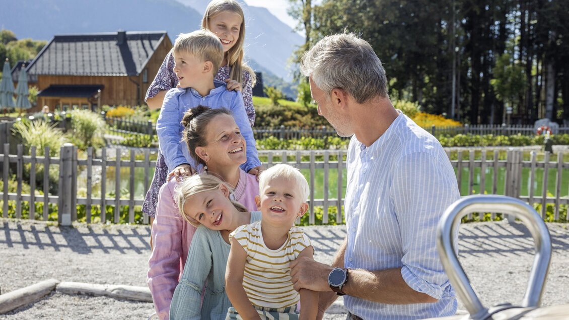 Eine fröhliche Familie posiert zusammen auf einem Spielplatz. Die Kinder lachen und genießen die Zeit im Freien. | © www.zloam.at