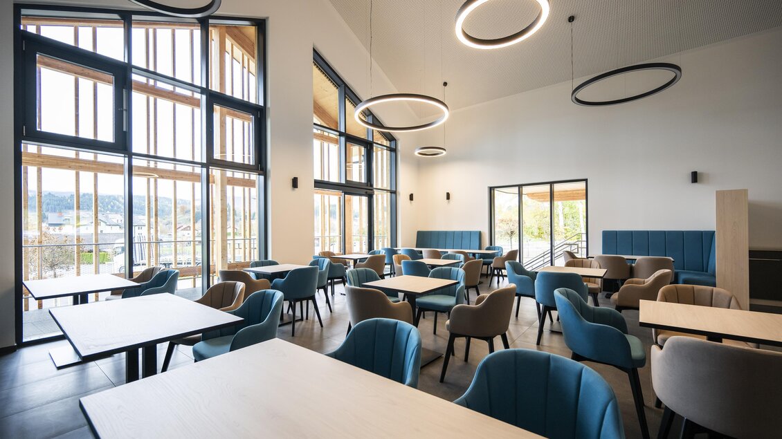 Ein modernes Restaurant mit hellen Fenstern und stilvollen Möbeln. Die Tische sind gemütlich angeordnet, und der Raum wirkt einladend und lichtdurchflutet. | © Gemeinde Neumarkt in der Steiermark