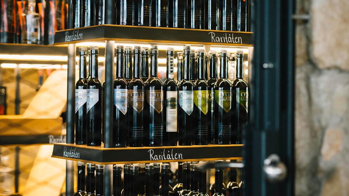 Ein Regal mit verschiedenen Weinsorten, gut sortiert und beleuchtet. Die Flaschen sind in mehreren Reihen angeordnet, mit verschiedenen Etiketten. | © Manufaktur Gölles