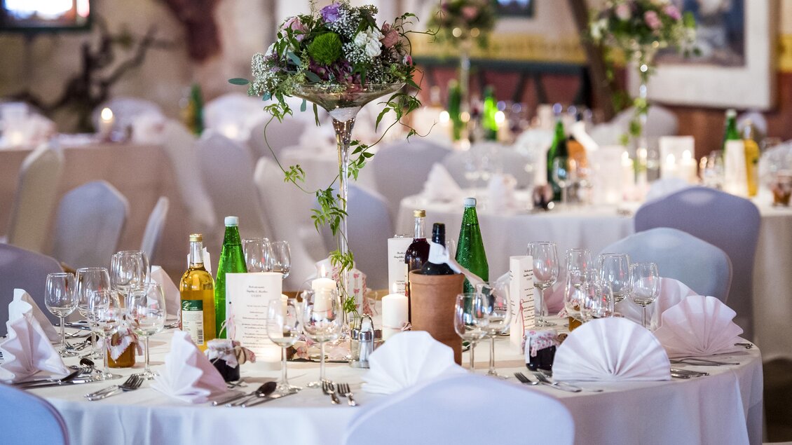 Ein elegant dekorierter Tisch für eine Veranstaltung mit Blumenschmuck und gläsernem Geschirr. Die Atmosphäre ist festlich und einladend. | © Gasthof Landhotel Hubmann