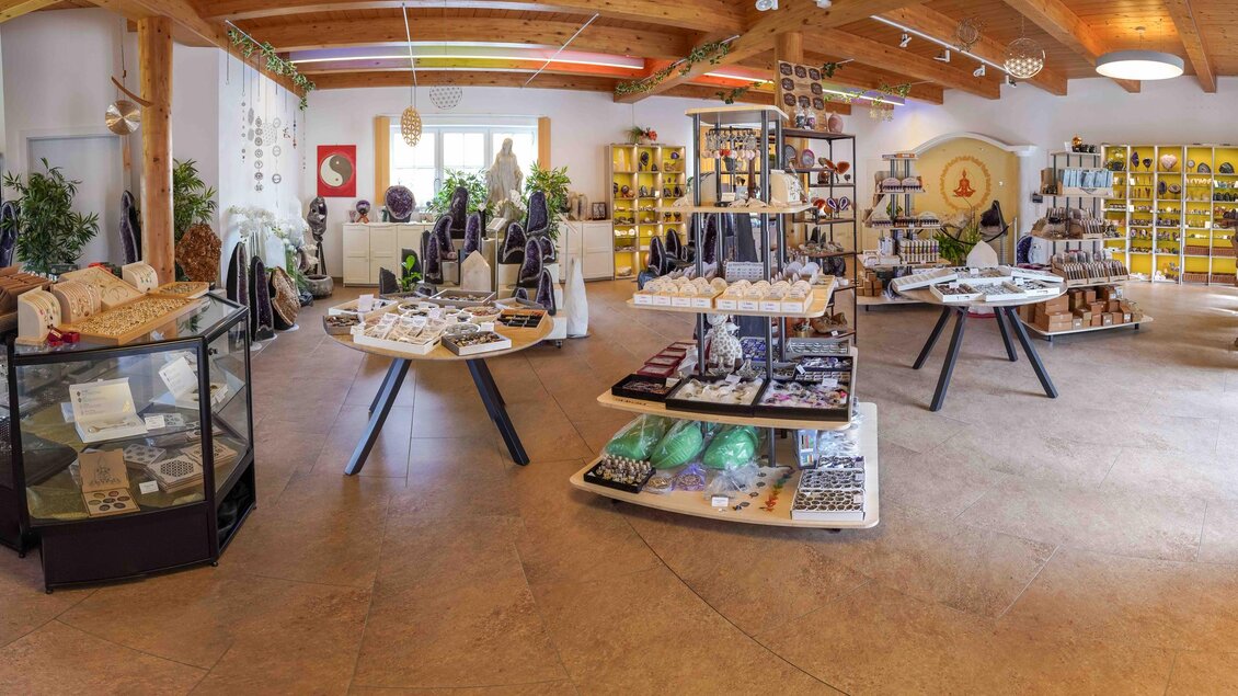 Ein gemütlicher Laden mit verschiedenen Regalen voll von Kristallen, Schmuck und spirituellen Gegenständen. Helle Farben und eine angenehme Atmosphäre laden zum Stöbern ein. | © Fam. Offenbacher