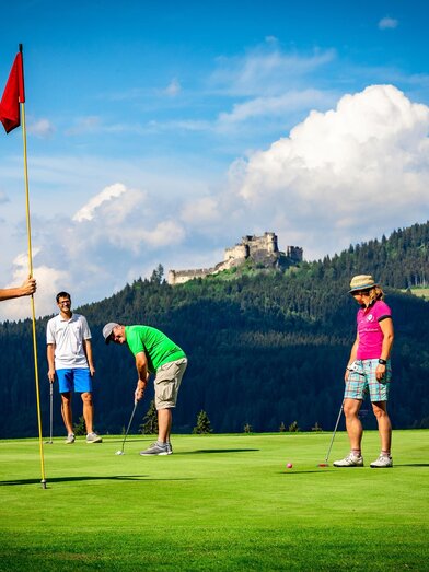 Golfen mit Blick auf die Burgruine Steinschloss | © SMG Mariahof | Mediadome | © SMG Mariahof