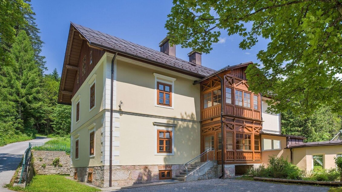 Ein charmantes Haus mit einem klassischen Design und einem Holzveranda. Umgeben von Bäumen und einer ruhigen Straße. | © JUFA Hotels