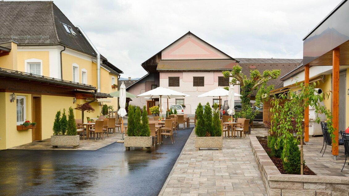 Ein gemütlicher Innenhof mit Terrassen, Tischen und Stühlen. Umgeben von Gebäuden und grünen Pflanzen zeigt der Raum eine einladende Atmosphäre. | © Erlebnisregion Murtal