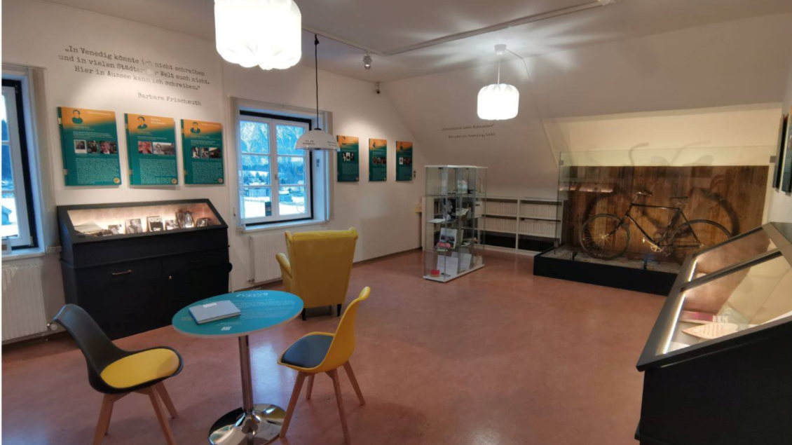 <p>Im Literaturmuseum Altaussee gibt es viele informativen Tafeln an den Wänden. In der Mitte stehen ein runder Tisch mit Stühlen und ein Vitrinenschrank, in dem das Herzl-Fahrrad präsentiert wird.</p> | © Kulturfux