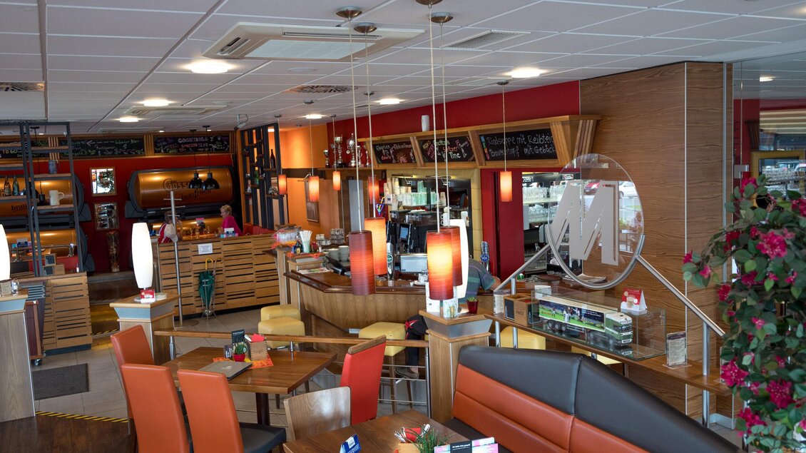 Ein modernes Restaurant mit warmen Farben und gemütlichen Sitzbereichen. Die Einrichtung ist einladend und gut beleuchtet. | © M-Rast