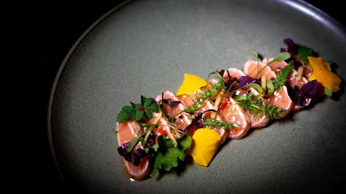 Modern angerichtetes Fischgericht  im Miss Cho mit Kräutern, Saucen und Gemüse auf Teller in der Bar Amouro in Graz. | © Miss Cho - aiola