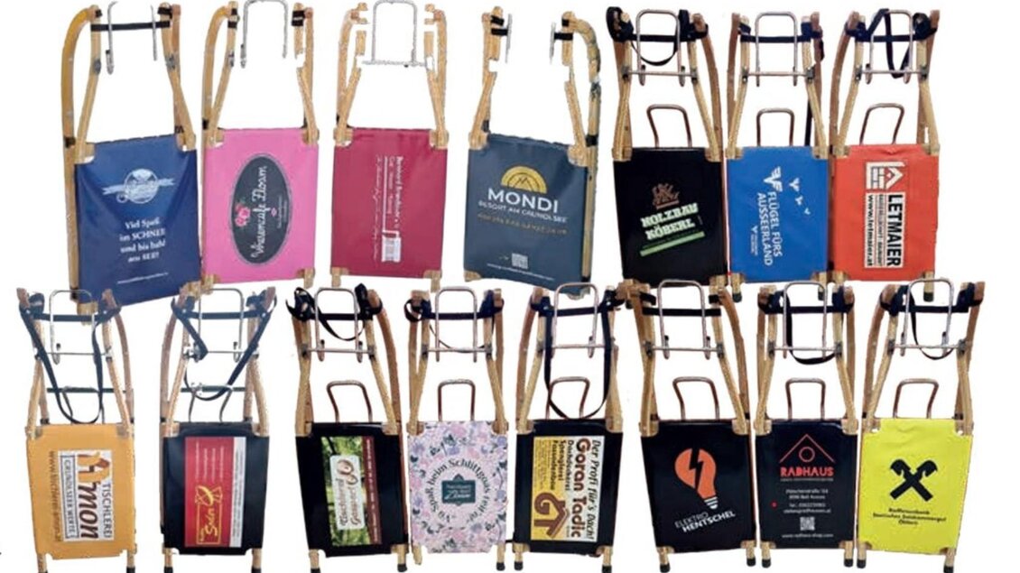 Eine Sammlung von verschiedenen Stühlen mit bunten Stofftüten. Jede Tüte trägt unterschiedliche Logos und Designs. | © Gemeinde Grundlsee