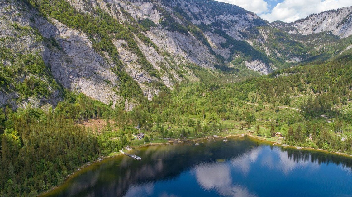 <p><p>Ein ruhiger See umgeben von hohen Bergen und grünem Wald. Der Himmel ist klar mit einigen Wolken.</p></p> | © Drohnenfotos.at-Andreas Tischler