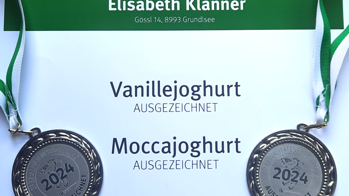 Zwei Medaillen für ausgezeichnete Joghurts, Vanille und Mocca. Die Medaillen sind auf einem zertifizierenden Dokument angeordnet. | © Butterer Hofladen