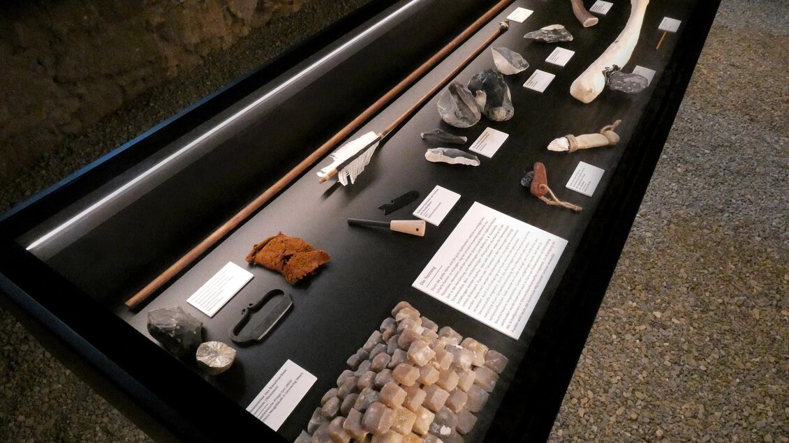 Museumsvitrine der Ausstellung Stein.Zeit. im Stift Rein mit Knochen, Pfeil, Steinwerkzeugen und Fundstücken aus der Steinzeit. | © Stift Rein