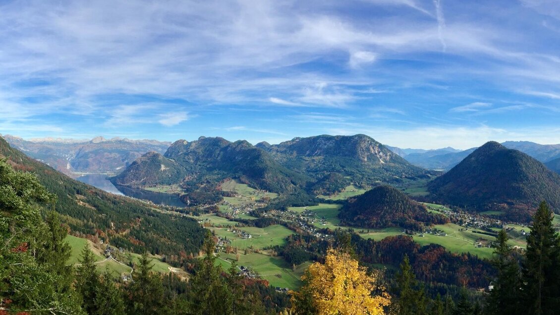 Traumhafter Blick von der Tressensteinwarte in Richtung Grundlsee und dem gleichnamigen See auf der linken Seite, umgeben von den Bergen des Ausseerlandes. Der Himmel ist blau, die Wiesen um Grundlsee in sattem grün gefärbt. | © Bettina Scheck