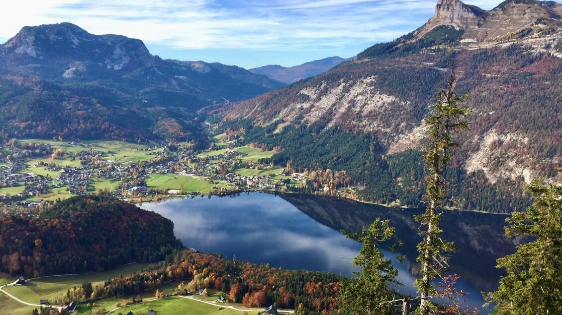 Traumhafter Blick von der Tressensteinwarte in Richtung Altaussee und seinem Hausberg Loser auf der rechten Seite. Am Fuße des Losers befindet sich der tiefblaue Altausseer See. Der Himmel ist blau, die Wiesen um Altaussee in sattem grün gefärbt. | © Bettina Scheck