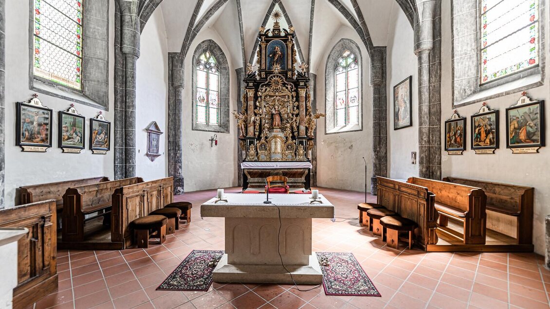 Eine ruhige Kirche mit einer schönen Altarpaar und bunten Fenstern. Die Bänke sind aus Holz und schaffen eine einladende Atmosphäre. | © TV Gesäuse