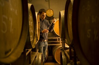 Seppi zwischen den Holzfässern im Keller | © Obsthof Neumeister, Josef Neumeister