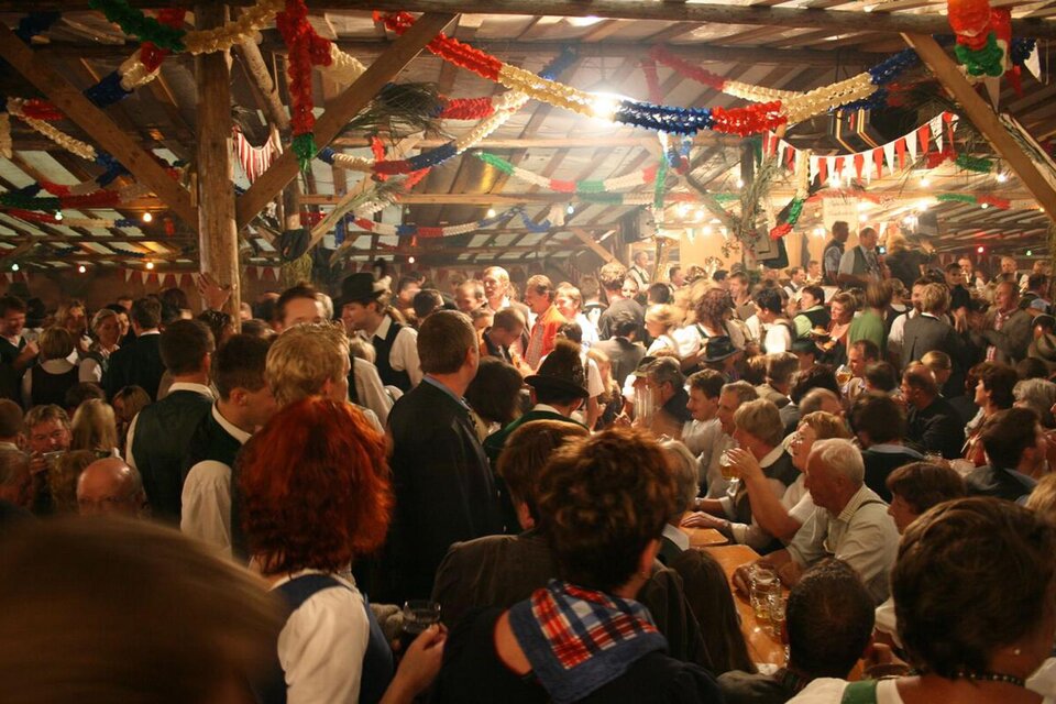 <p>Das Bierzelt in Altaussee ist eine lebhafte Festhalle mit vielen Menschen, die zusammen feiern. Festliche Dekorationen und fröhliche Stimmung prägen die Szenerie.</p> | © FF Altaussee