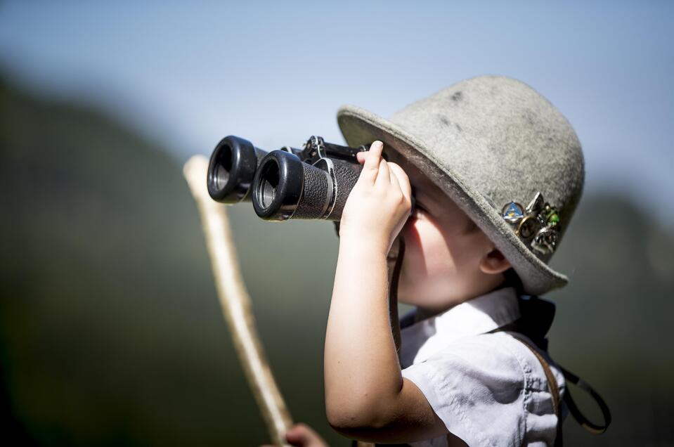 Kleiner Bub guckt durch ein Fernglas. | © Tom Lamm