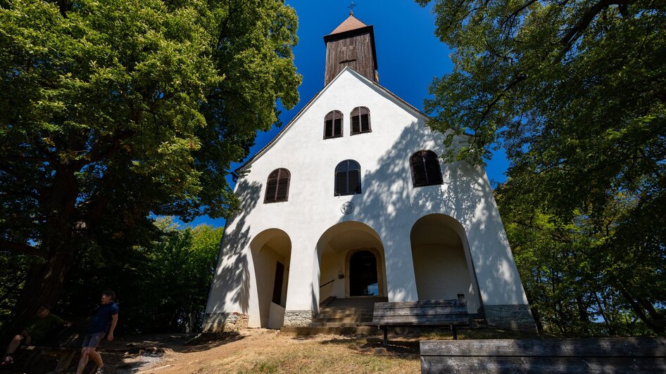 Wunderschöne Kirche in der Natur, umgeben von Bäumen.
