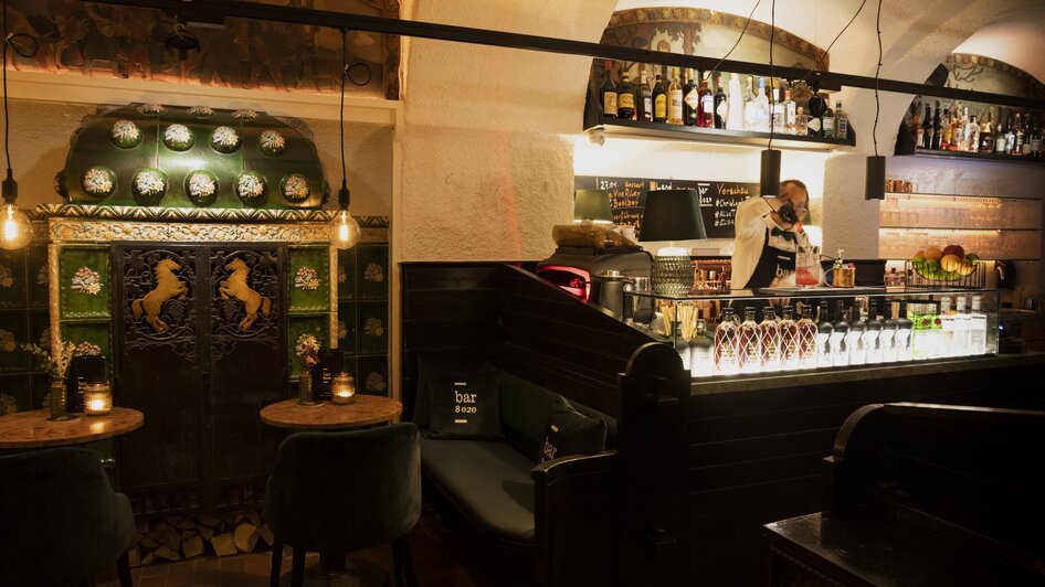 Gemütliche Bar mit dekorativem Interieur, Sitzbereichen und Bartender.