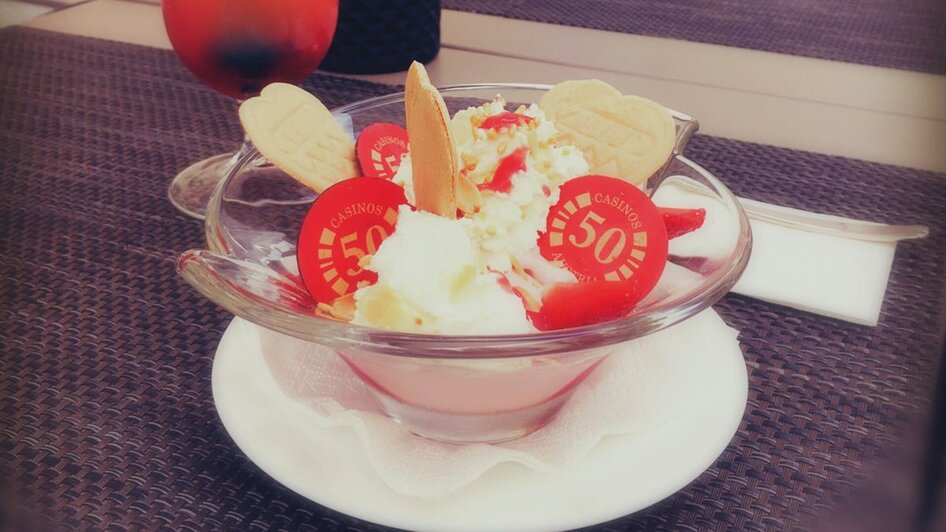 Ein bunter Cocktail und ein Eisbecher auf einem Tisch im Casino-Restaurant Graz.