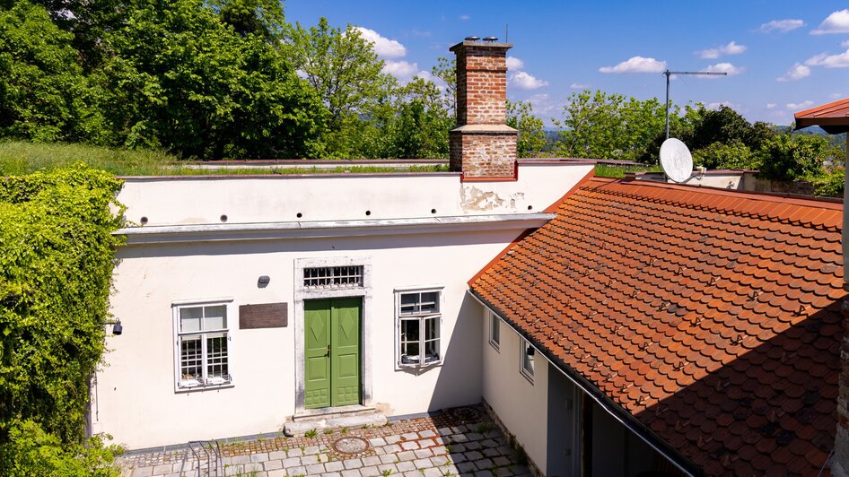 Das Cerrini-Schlössl mit grünem Eingang und Umgebung in Graz.
