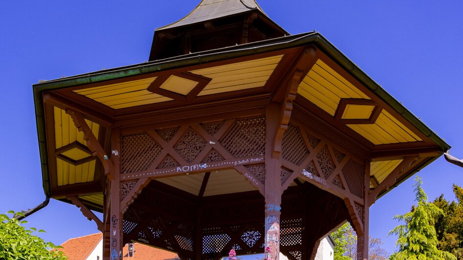 Pavillon umgeben von Blumen und grünem Gras am Schlossberg in Graz.