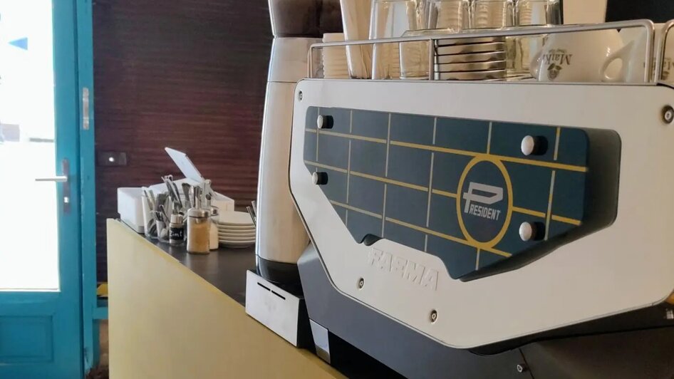 Theke eines Cafés mit Kaffeemaschine und Gläsern. | © coffee ride
