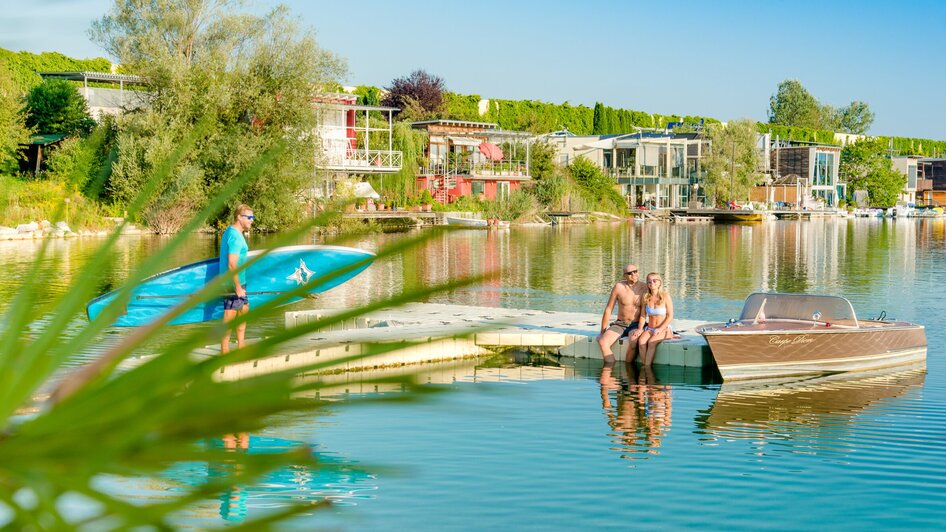 Entspannende Szene mit Paddler und Paar am See.