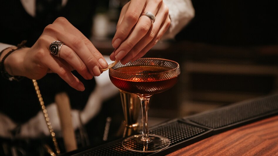 Ein Barkeeper, der einen Cocktail zubereitet.