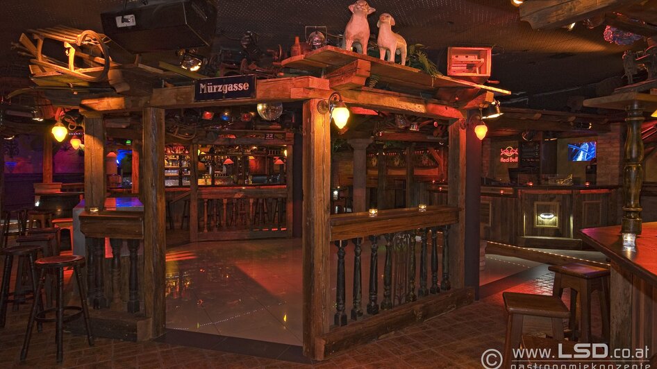 Gemütliche Bar mit Holzdekor und interessanter Beleuchtung.