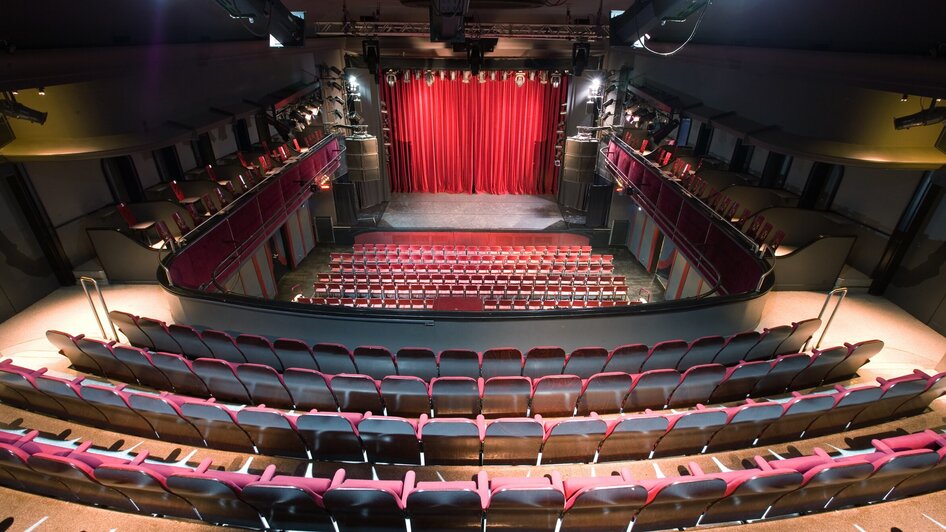 Orpheum leerer Theatersaal mit roten Sesseln und rotem Vorhang im Orpheum Graz.